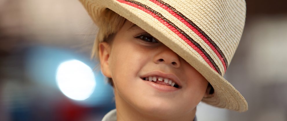 cute boy in fedora with crooked teeth