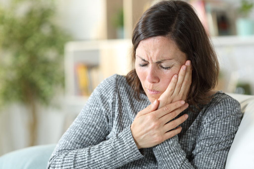 woman holding her face in pain