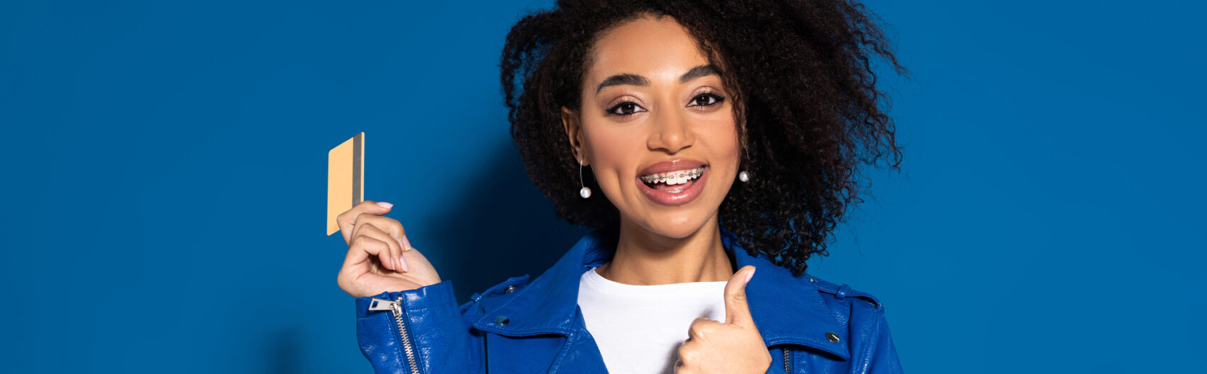 woman with braces holding credit card