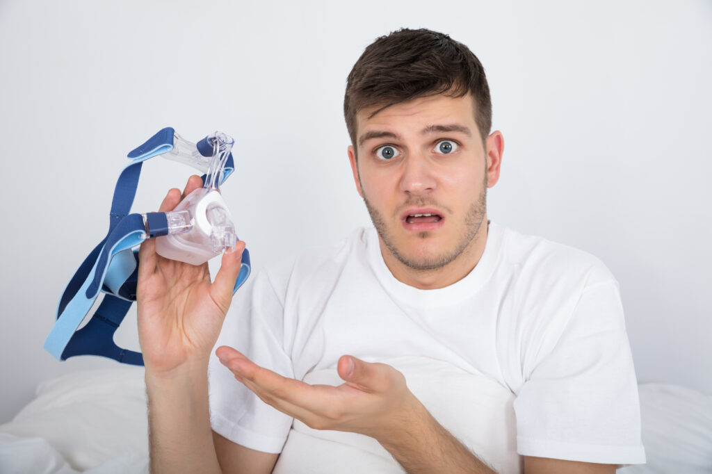 young man holding cpap machine