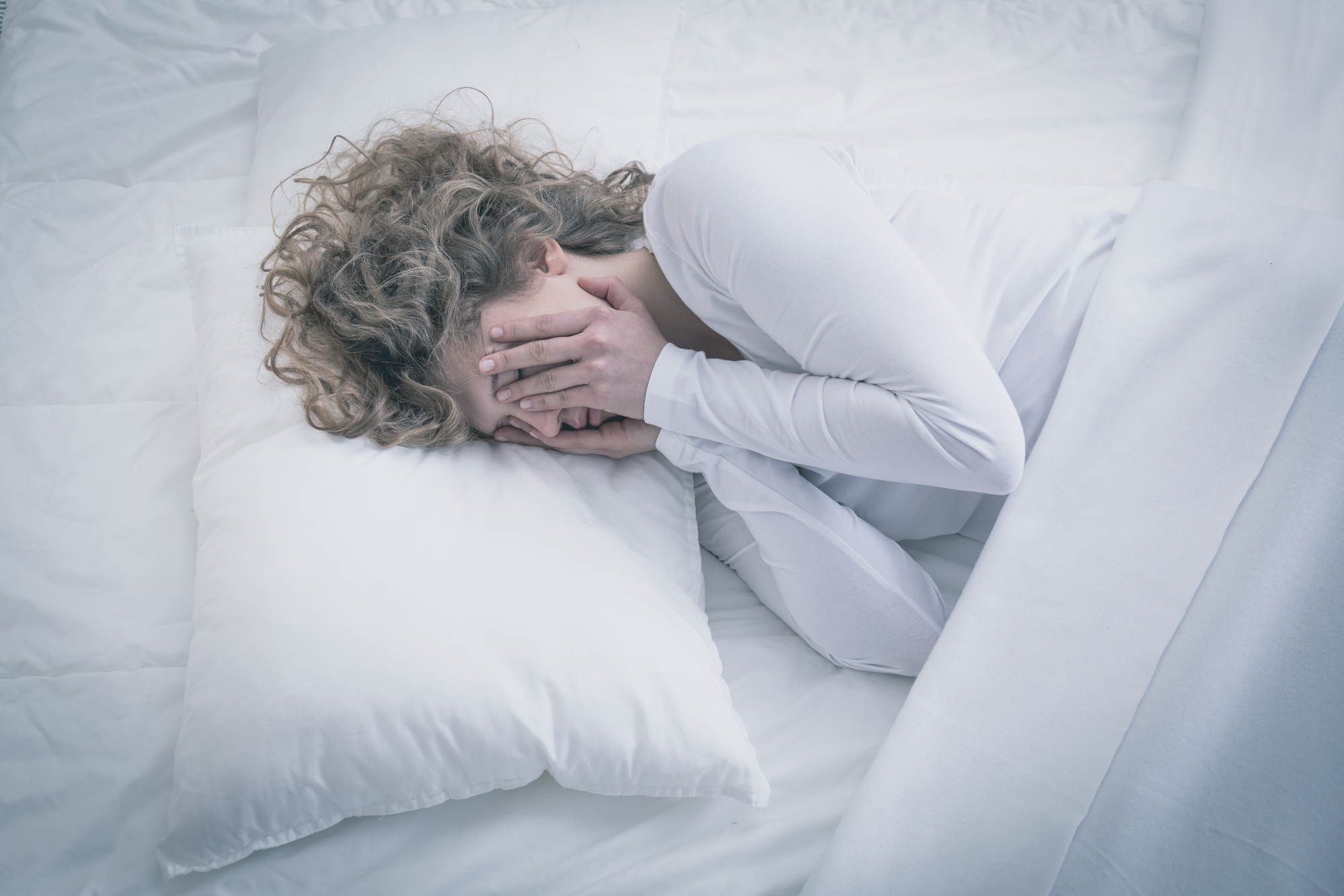 woman rubbing face and struggling with sleep