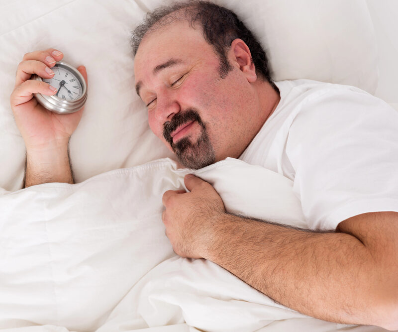 man holding a timer, happy after a restful night of sleep