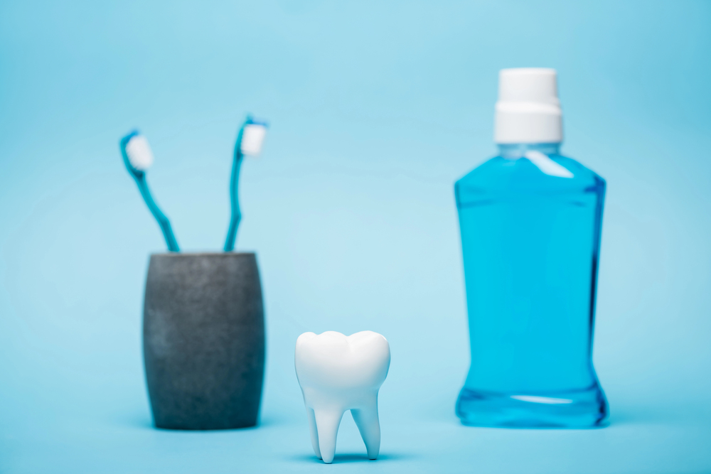 tooth, toothbrushes, and mouthwash on blue background