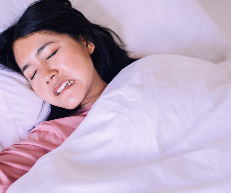Asian woman sleeping and grinding teeth in bedroom,Female tiredness and stress