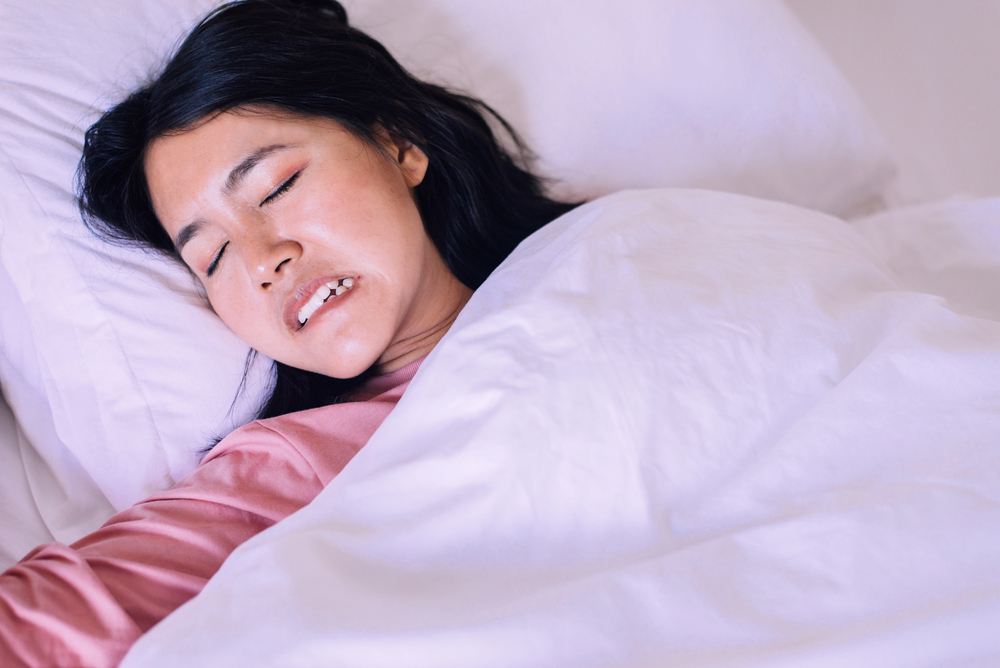 Asian woman sleeping and grinding teeth in bedroom,Female tiredness and stress